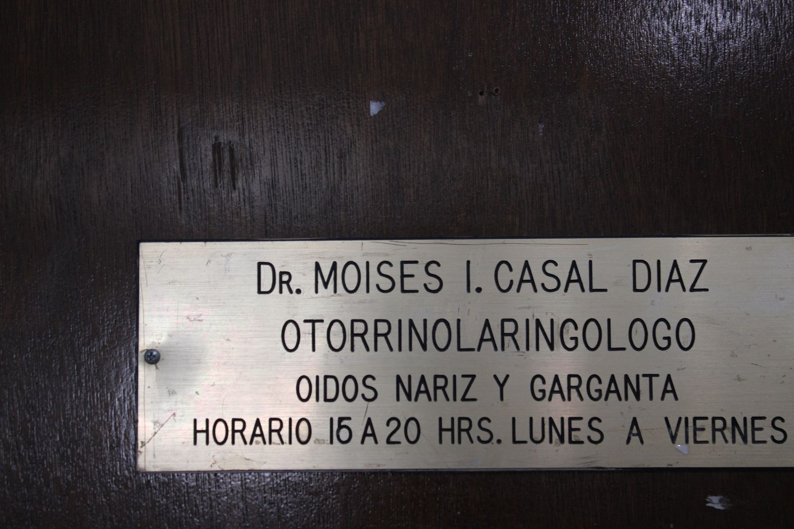 Placa dorada en la puerta del consultorio: Dr. Moisés I. Casal Díaz, otorrinolaringólogo, oídos, nariz y garganta