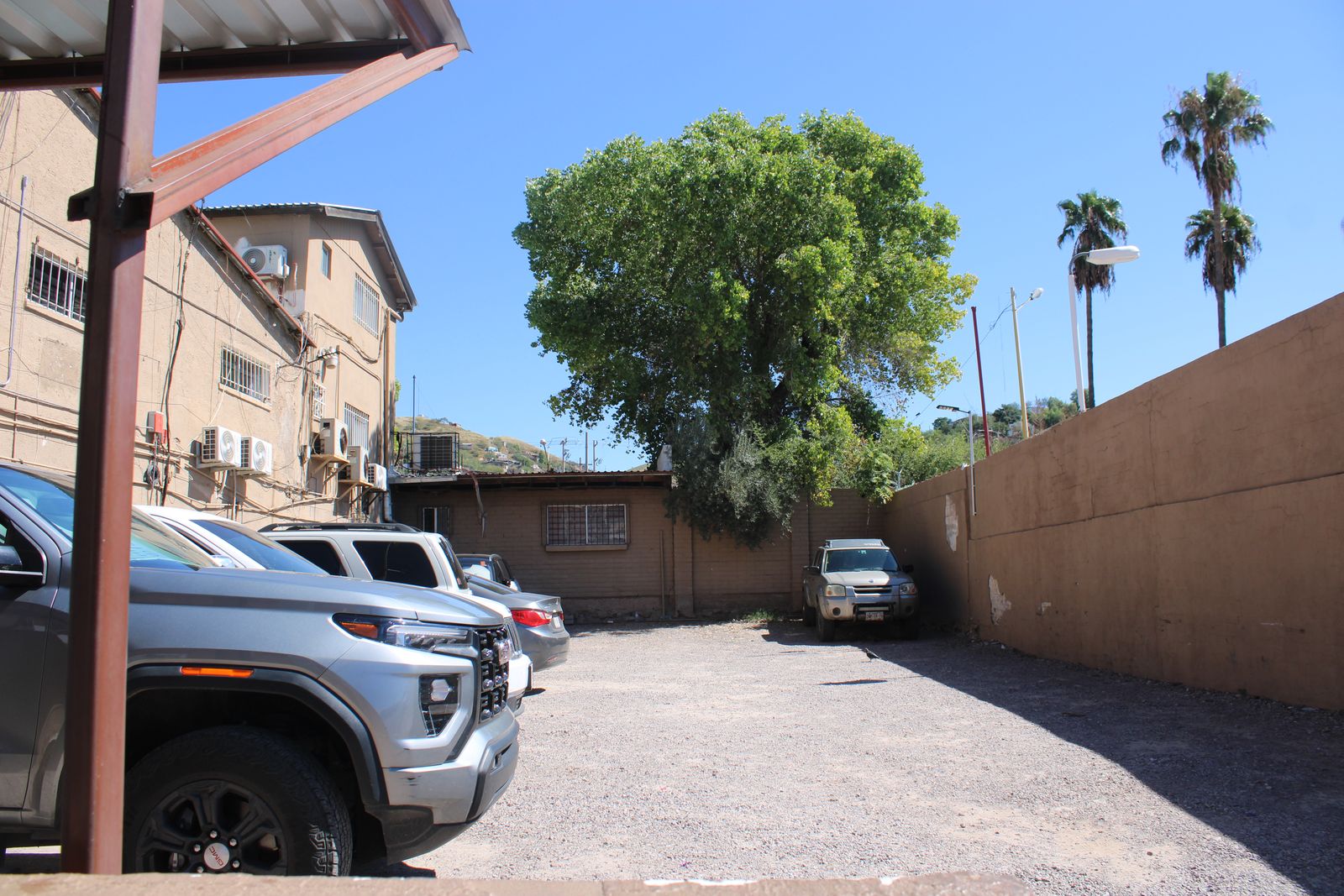 Estacionamiento para pacientes de Clínica Santa Elena, con camionetas estacionadas junto al edificio