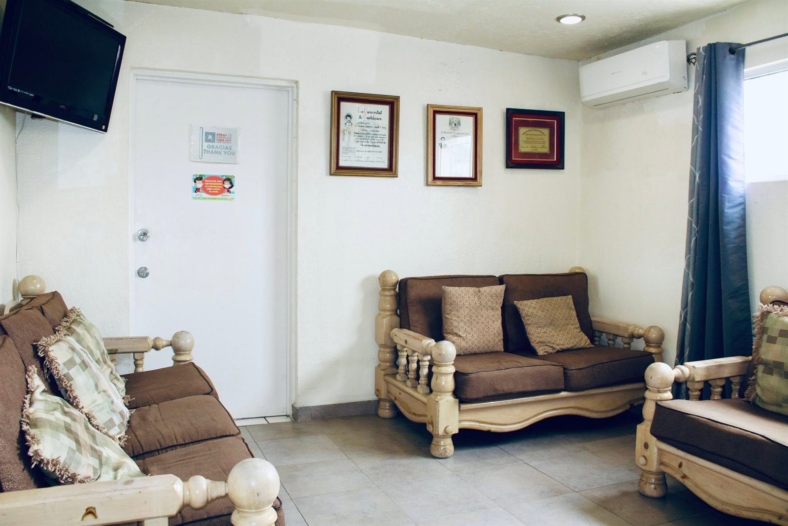Sala de espera de Clínica Santa Elena con los diplomas del Dr. Casal en la pared